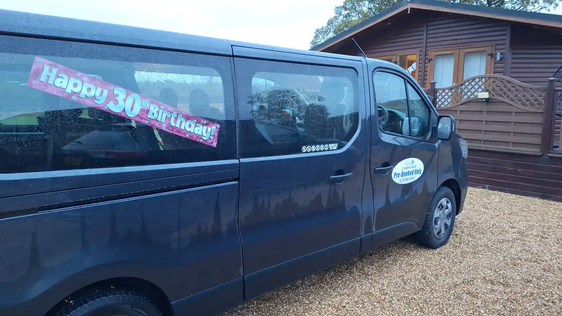 Minibus hire Downham Market – G and M Taxis Renault minibus decorated for a 30th birthday group trip outside a Norfolk lodge.